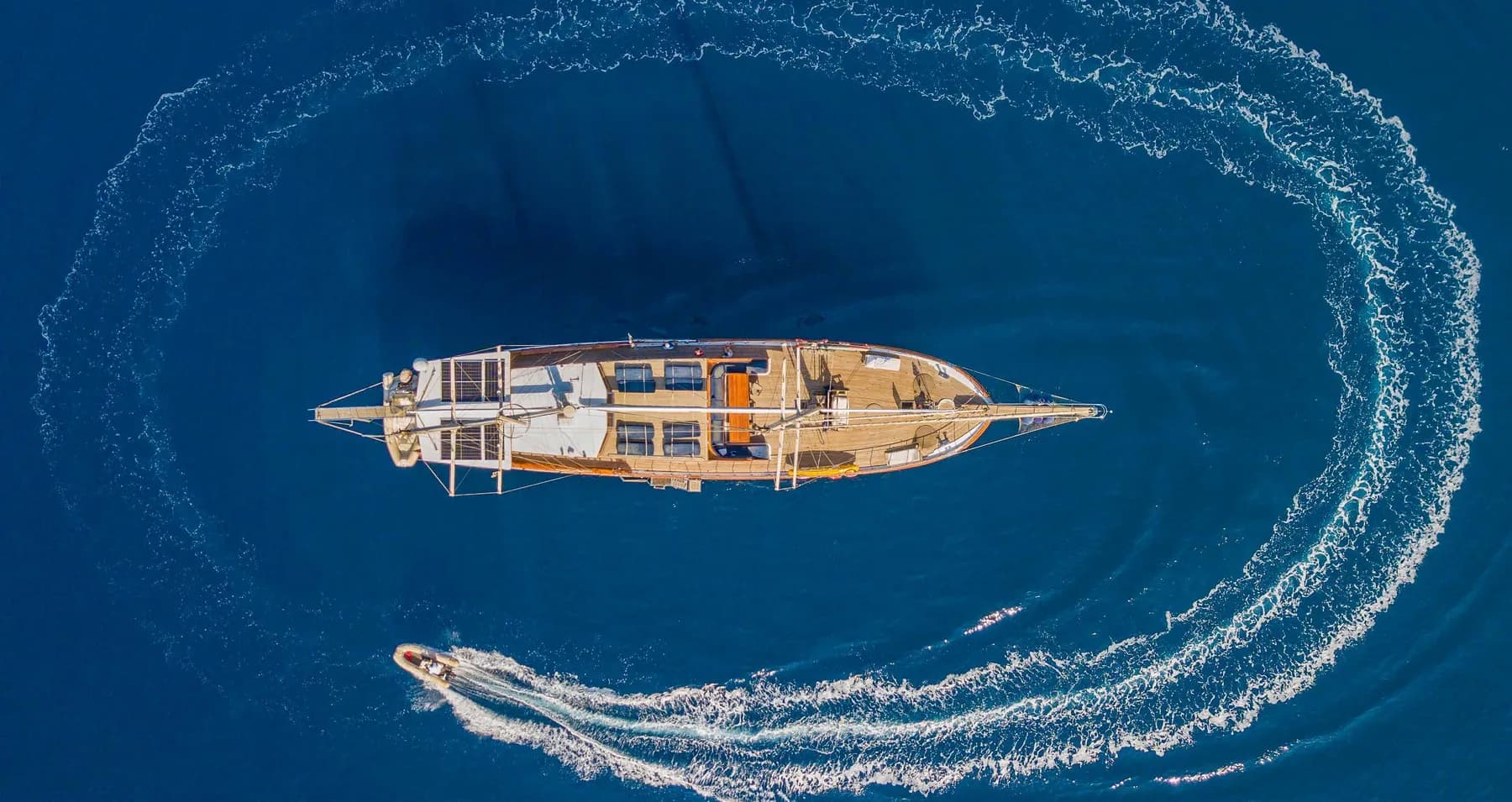 Aerial view of the Let's Dance gulet with tender wake