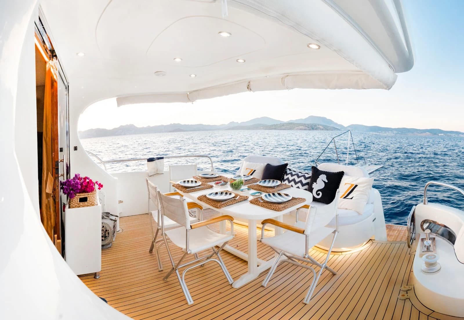 Shaded Aft Deck Dining and Lounge Area with Teak Floor and Luxury Cushion Monograms