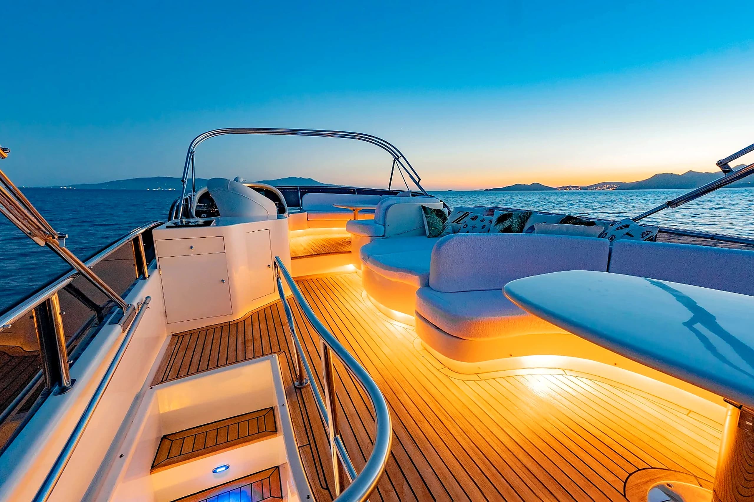 Upper Flybridge Deck with Glowing Amber Teak Lighting and Sunset Panorama