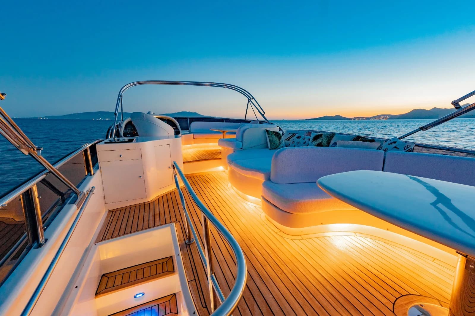 Upper Flybridge Deck with Glowing Amber Teak Lighting and Sunset Panorama